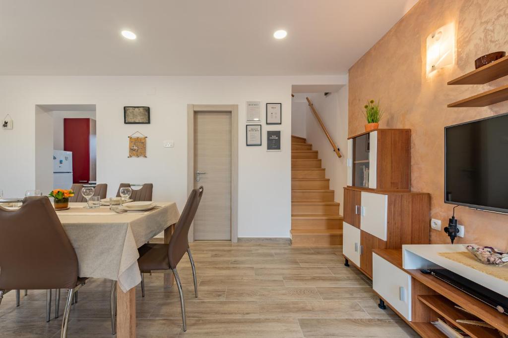 jadalnia ze stołem i krzesłami oraz telewizorem w obiekcie R&B Family Apartments w mieście Sveti Filip i Jakov