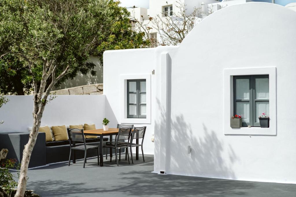 a patio with a table and chairs in a building at 3-Room, 3-Bath Family Villa with Massive Pool, Central Location, Seconds from Cliff! in Imerovigli