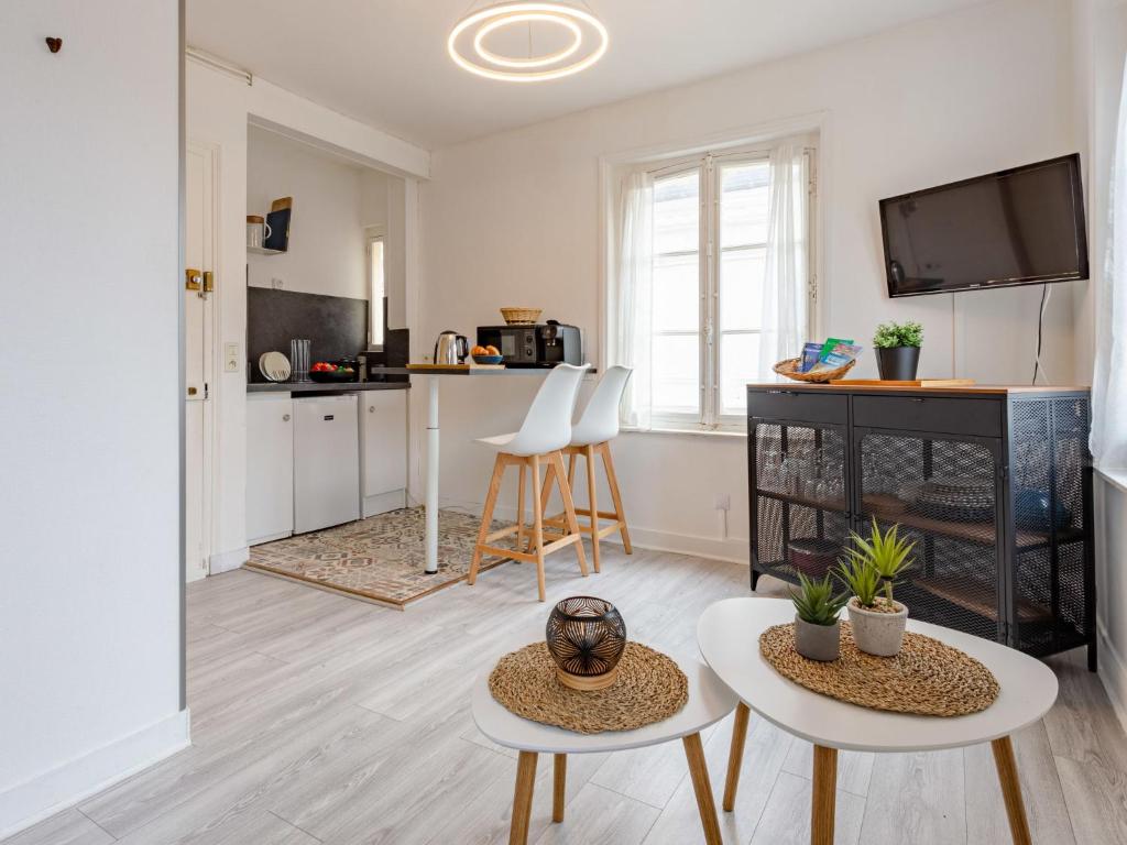 uma sala de estar com duas mesas e uma televisão em Studio La Batelière by Interhome em Trouville-sur-Mer