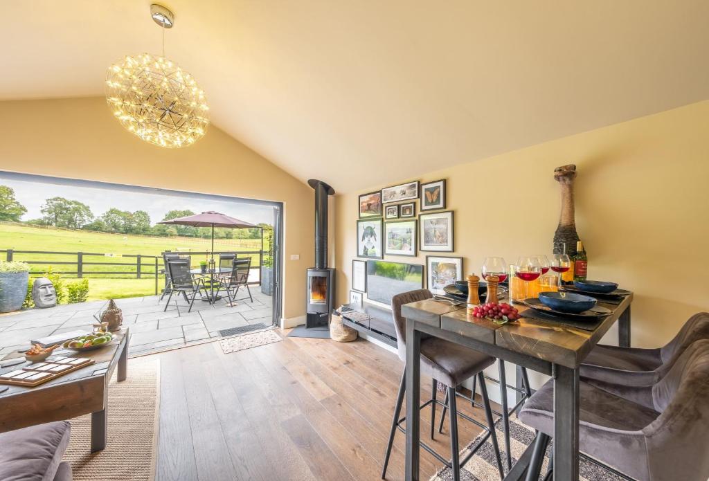 a living room with a table and chairs and a patio at The Haybarn in Cranleigh