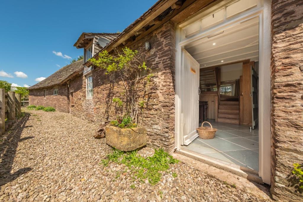 a stone house with a door leading to a courtyard at The Garden Barn in Peterchurch