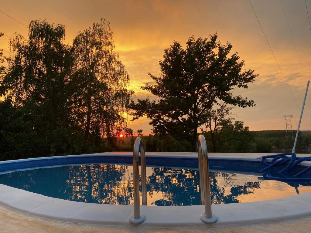 una piscina con puesta de sol en el fondo en Predivna kuća na Dunavu en Krčedin