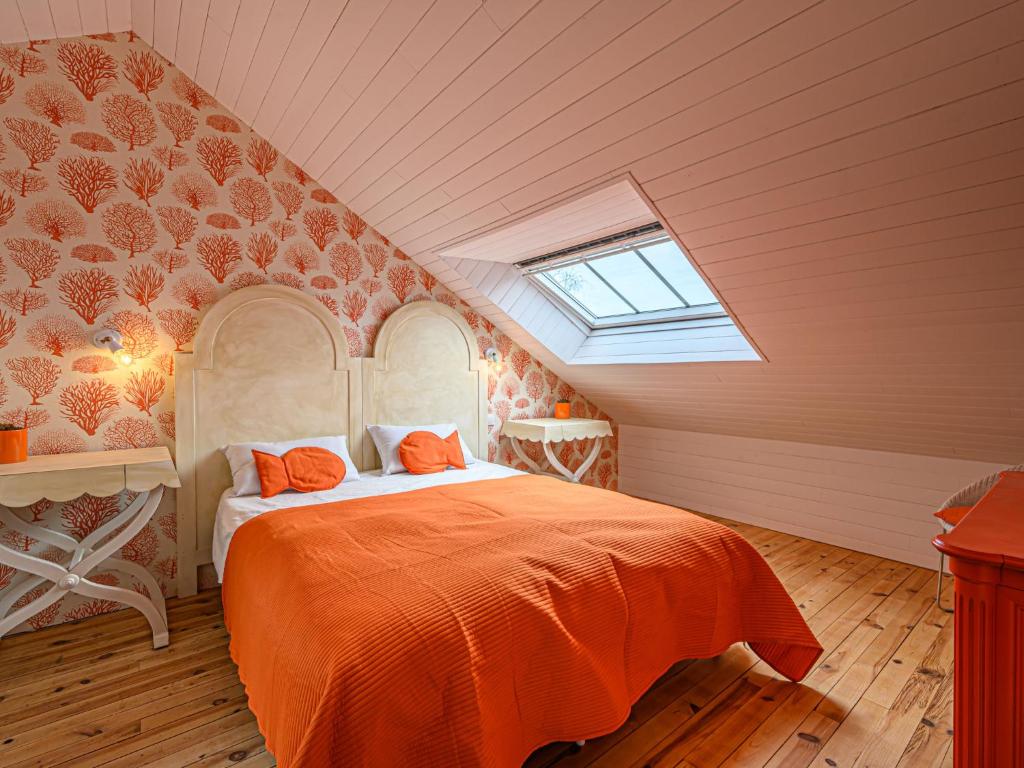 a bedroom with an orange bed in a attic at Holiday Home Saint-Colomban-2 by Interhome in Carnac