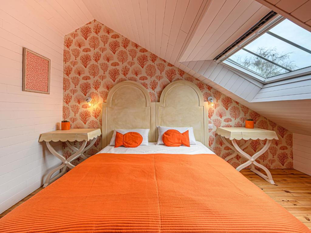 a bedroom with an orange bed in a attic at Holiday Home Saint-Colomban-2 by Interhome in Carnac