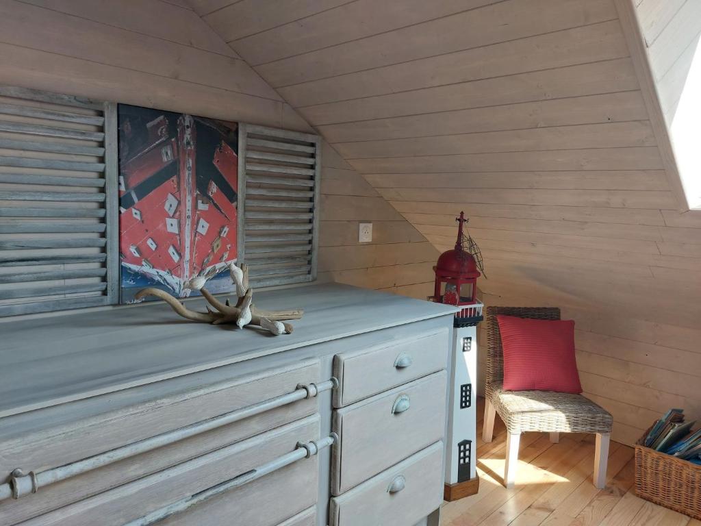 a wooden room with a dresser and a chair at Holiday Home Saint-Colomban-2 by Interhome in Carnac