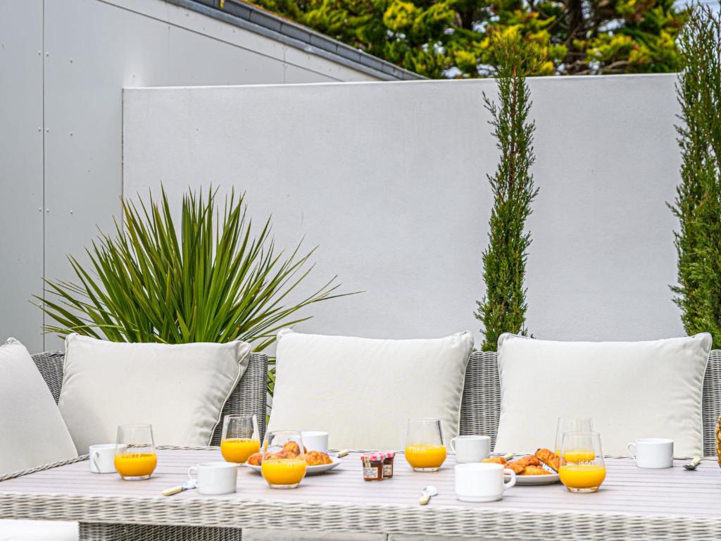 an outdoor table with orange juice and fruit on it at Holiday Home Saint-Colomban-2 by Interhome in Carnac