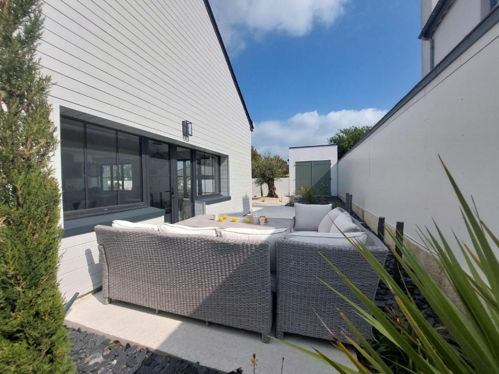 a backyard patio with a couch and a table at Holiday Home Saint-Colomban-2 by Interhome in Carnac