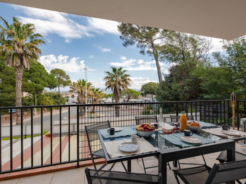 a table and chairs on a balcony with a view of a street at Apartment Le Cyrnos by Interhome in Saint-Aygulf