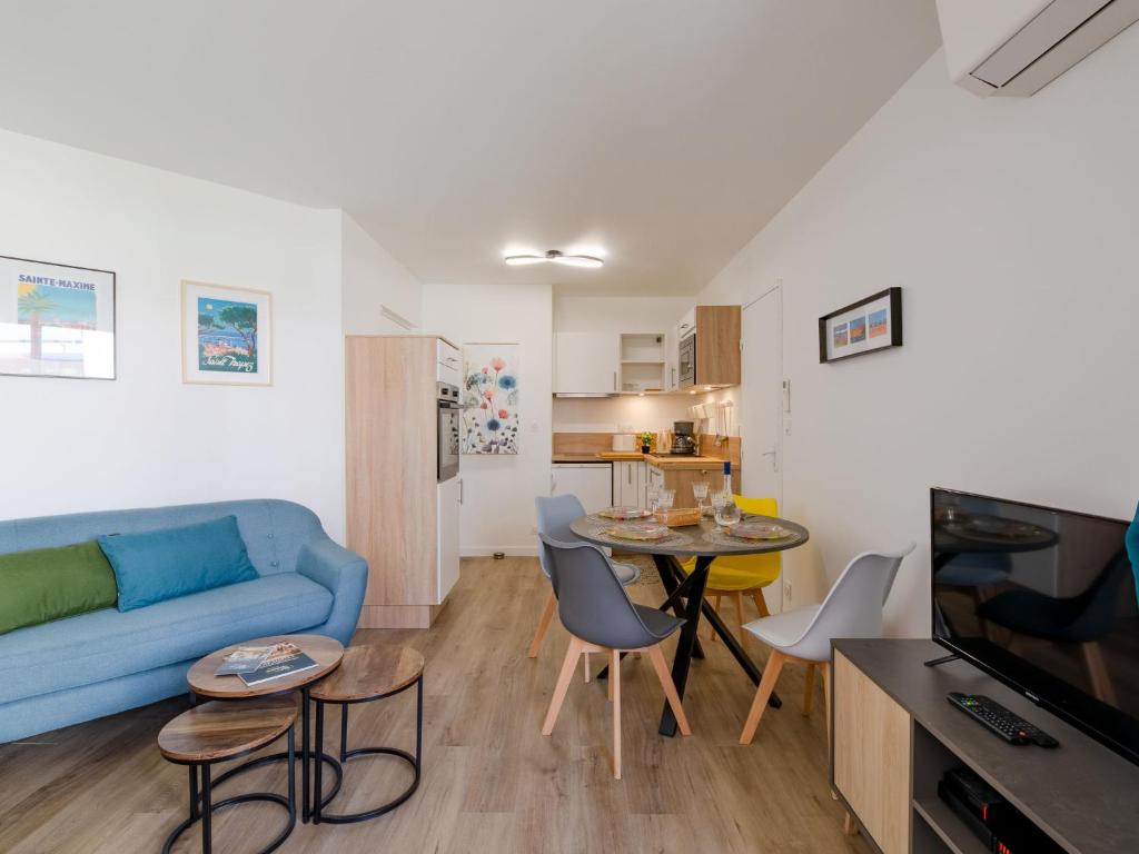 un salon avec un canapé bleu et une table dans l'établissement Apartment Régina-14 by Interhome, à Sainte-Maxime