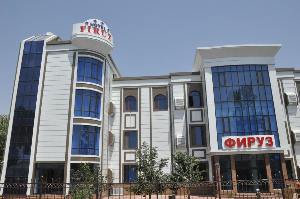 a building with a sign on top of it at Firuz Hotel in Khujand