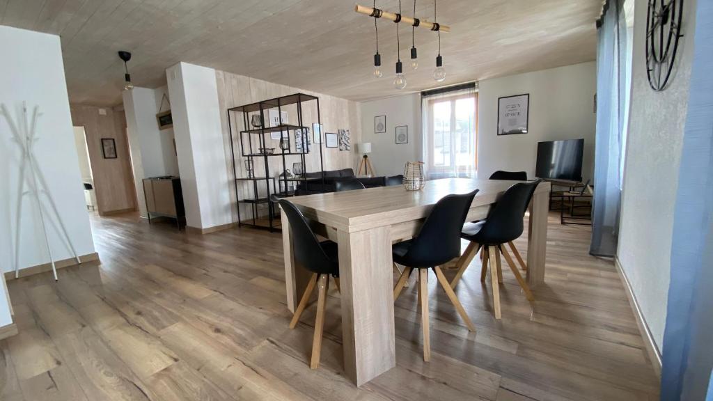 ein Esszimmer mit einem Holztisch und schwarzen Stühlen in der Unterkunft Hostellerie des Princes-Evêques - La Fleur de Lys in Pruntrut