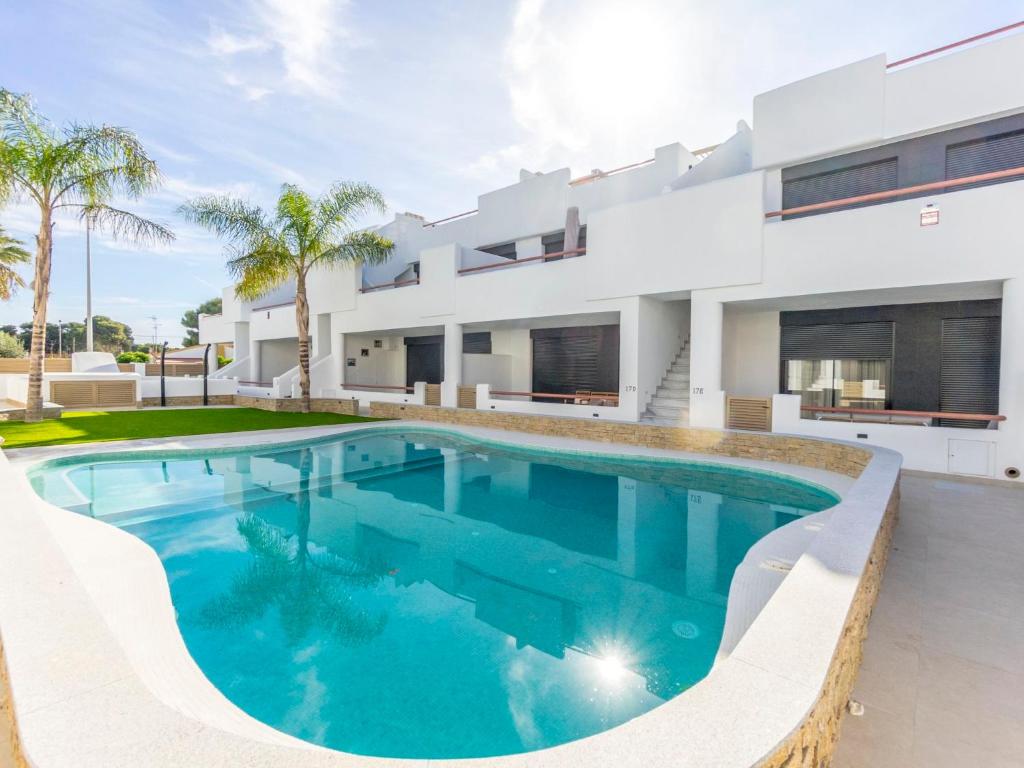 a swimming pool in front of a house at Apartment Tropical Beach Penthouse by Interhome in Santiago de la Ribera