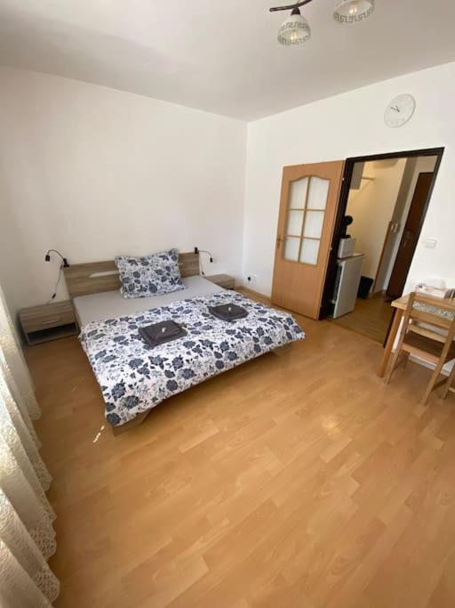 a bedroom with a bed and a wooden floor at Apartmán U Mendláku in Brno