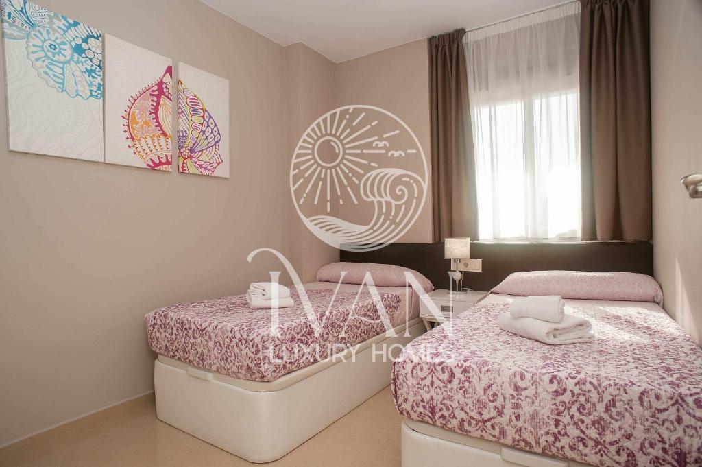 - une petite chambre avec 2 lits et une table dans l'établissement Casa Luna IVAN LUXURY HOMES 1ªPta Norte 1ªLinea, à Oropesa del Mar
