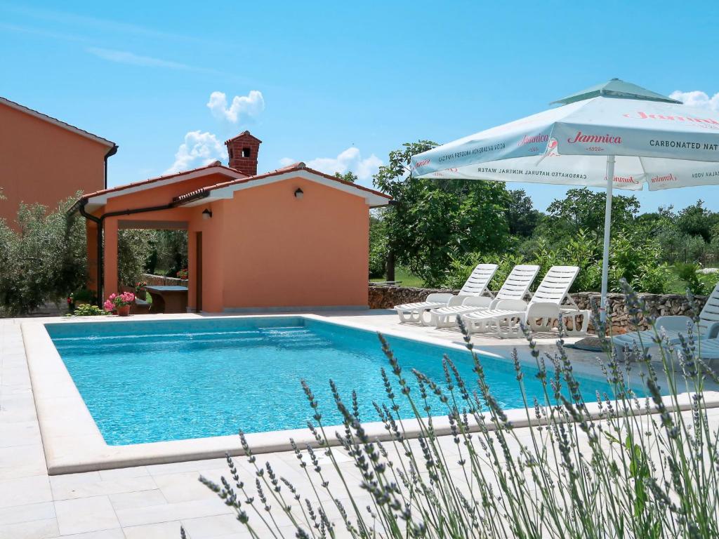 - une piscine avec des chaises et un parasol dans l'établissement Apartment Martina - LBN377 by Interhome, à Krnica