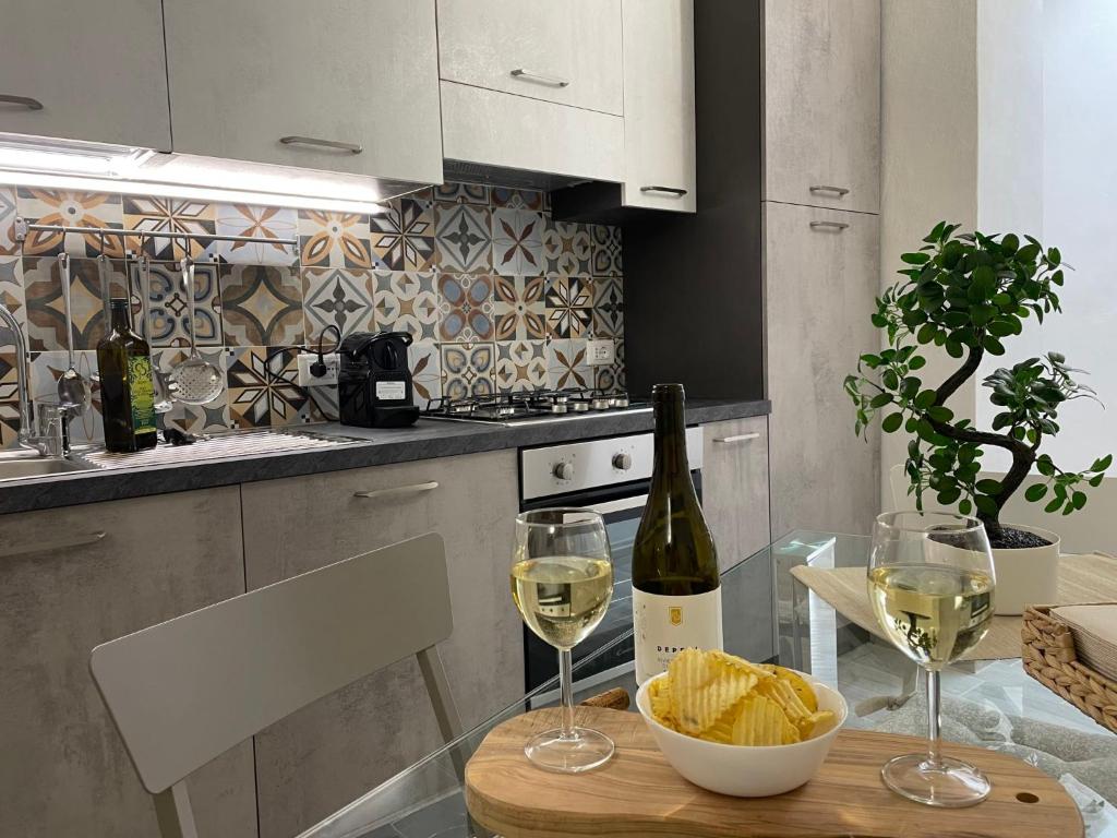 een keuken met een tafel met twee glazen wijn bij Apartment La Finestra sulla Piazza by Interhome in Imperia