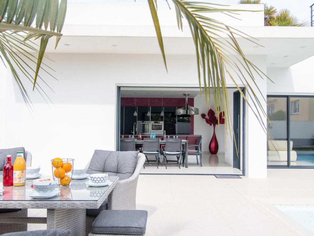 a patio with a table and chairs and a kitchen at Holiday Home L'Oustaloun by Interhome in Saint-Aygulf