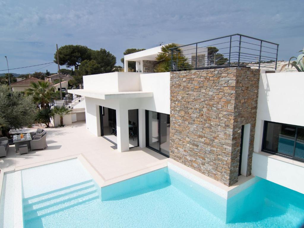 uma villa com uma piscina e uma casa em Holiday Home L'Oustaloun by Interhome em Saint-Aygulf