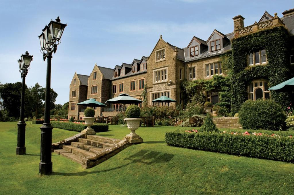 uma casa grande com um pátio verde com uma luz de rua em South Lodge em Lower Beeding