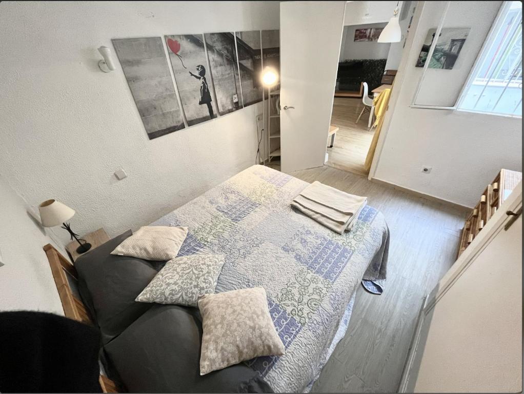 a small bedroom with a bed with pillows on it at Apartamento Plaza de los Naranjos in Marbella