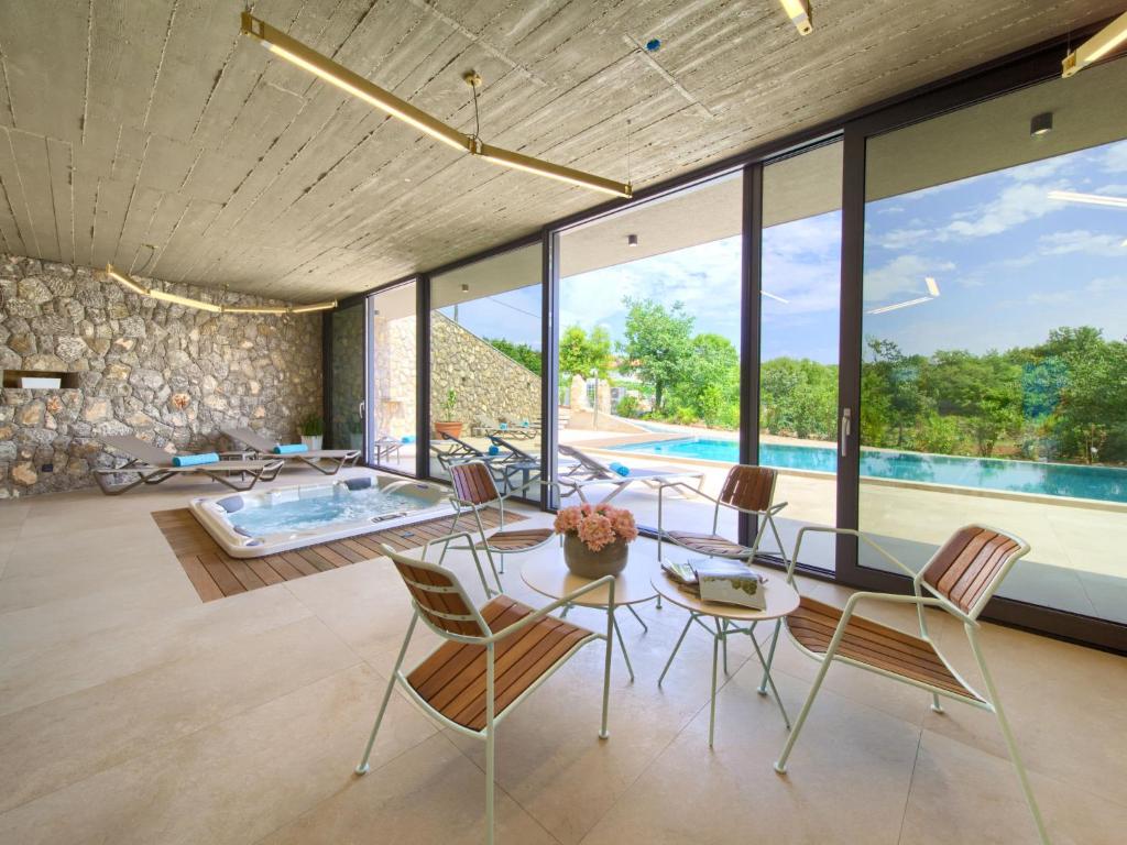 a dining room with a table and chairs and a pool at Holiday Home Jerini Main House by Interhome in Vrh