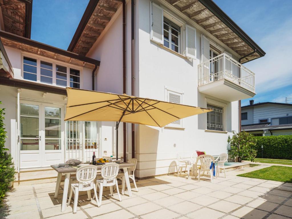 リド・ディ・カマイオーレにあるHoliday Home Villa Clara by Interhomeのパティオ(テーブル、椅子、黄色の傘付)
