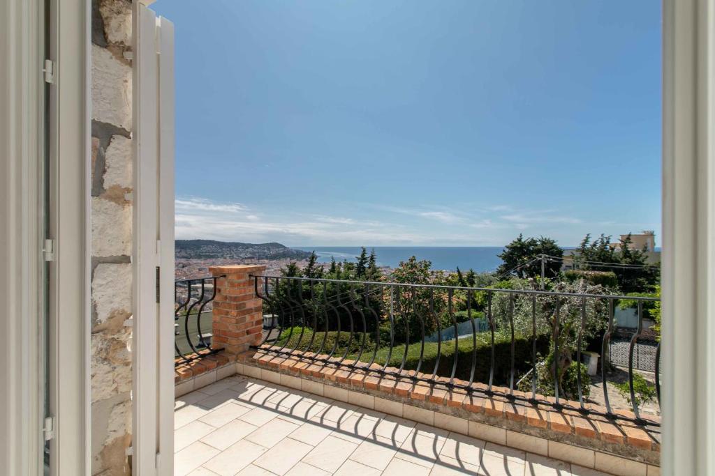 - une porte donnant sur un balcon avec vue sur l'océan dans l'établissement Maison Bianchi - Villa Saint Pierre de Feric, à Nice
