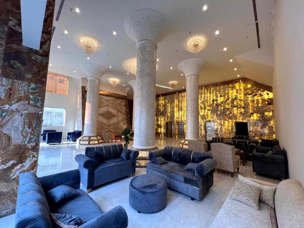 a living room with blue couches and a lobby at فندق الفيروز مكة 3 in Makkah