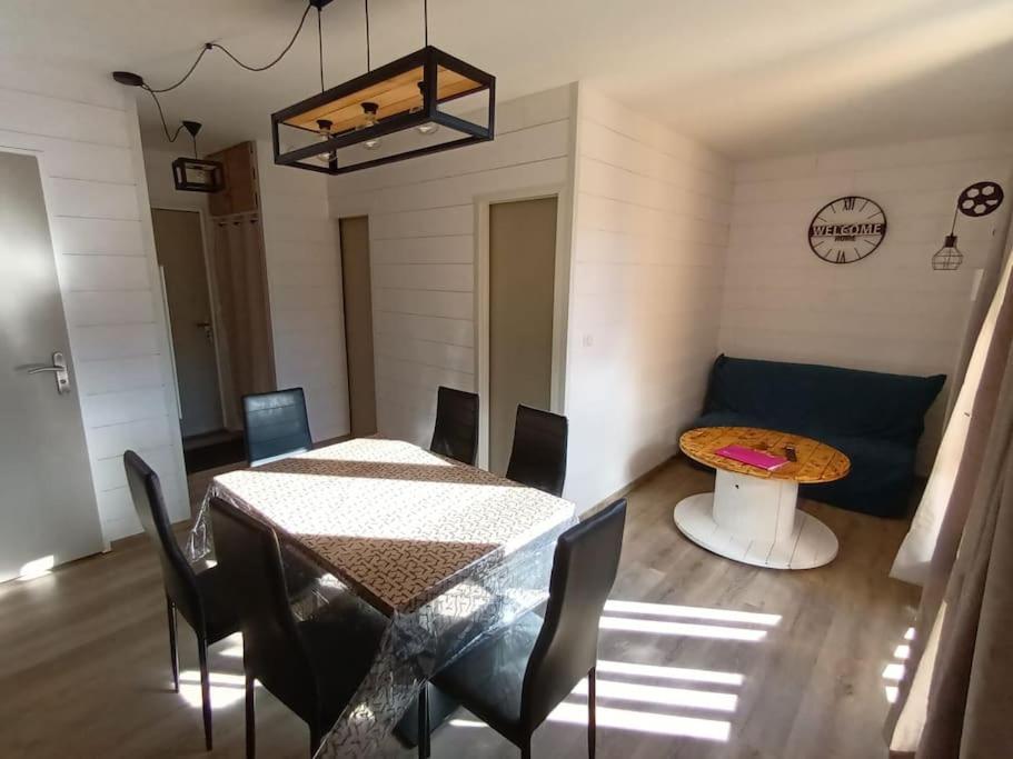 uma sala de estar com uma mesa e um sofá em location Appartement Bonascre toutes saisons em Ax-les-Thermes