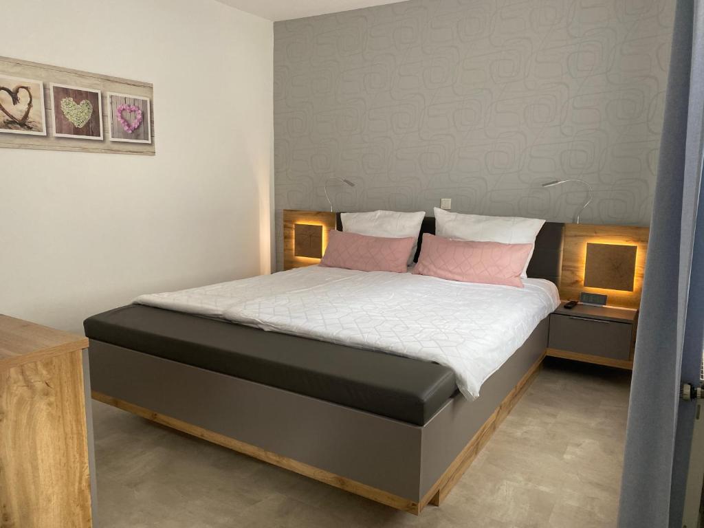 a bedroom with a bed with two pink pillows at Ferienwohnung Junglen an der Mosel in Zeltingen-Rachtig