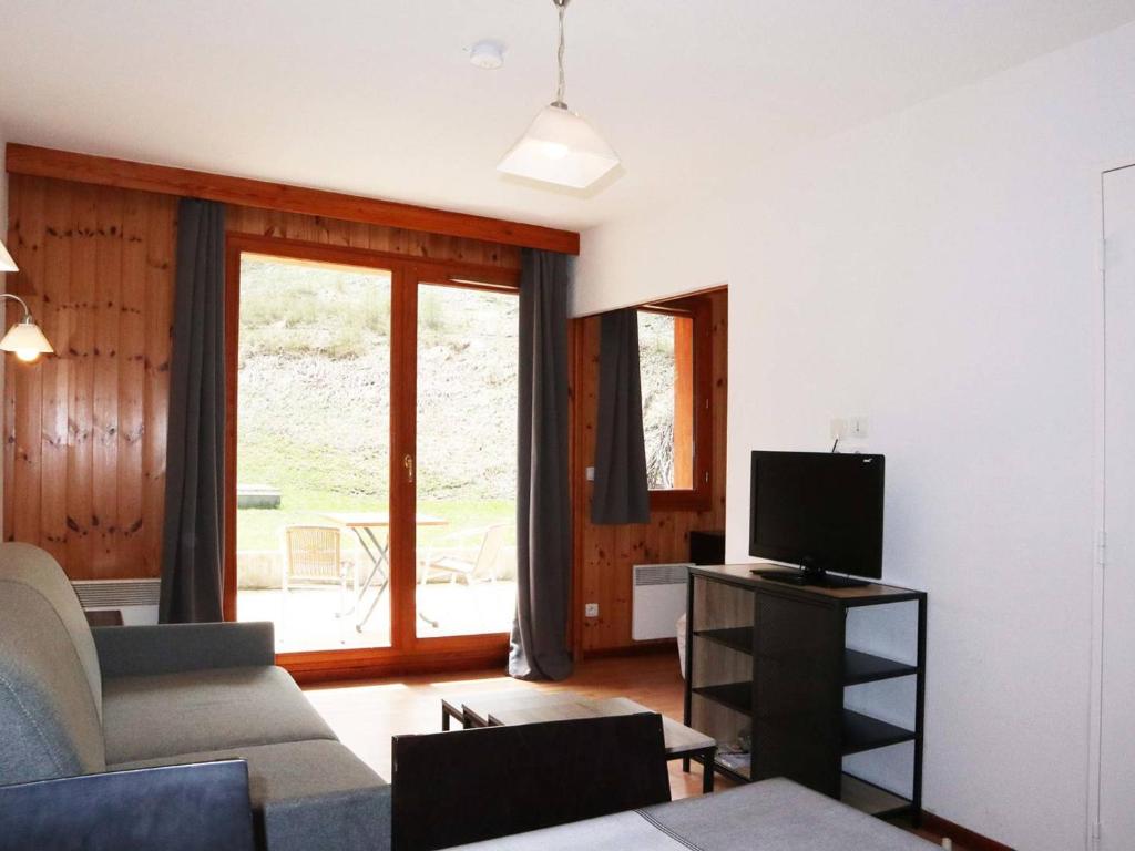 un salon avec un canapé et une télévision dans l'établissement Appartement Confort 4 pers. aux Orres 1800 avec Piscine, Sauna, Hammam et Wifi Gratuit - FR-1-322-89, aux Orres