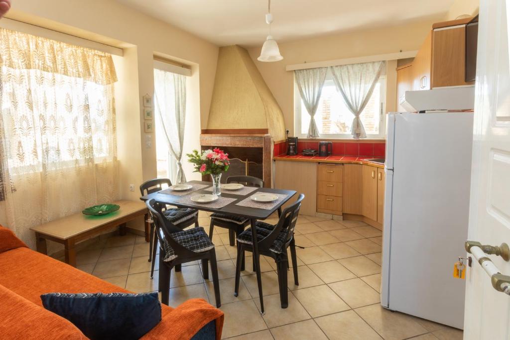 a kitchen with a table with chairs and a refrigerator at Yukas Home Xylokastro for 3 persons by MPS num 1 in Xylokastron