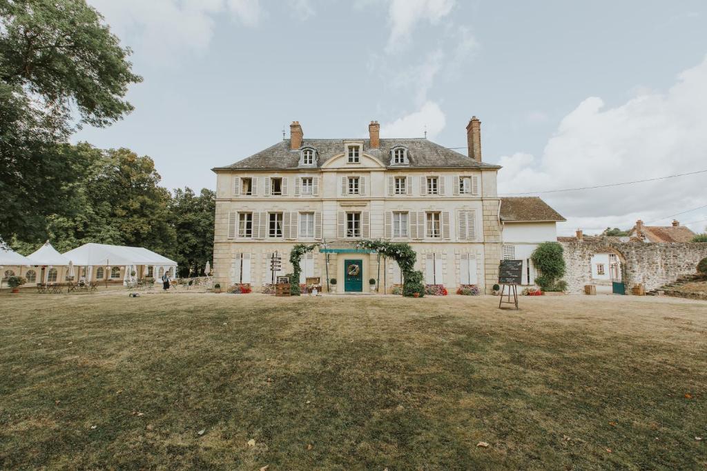 una gran casa blanca con un gran patio en Chateau de Bellefontaine, 