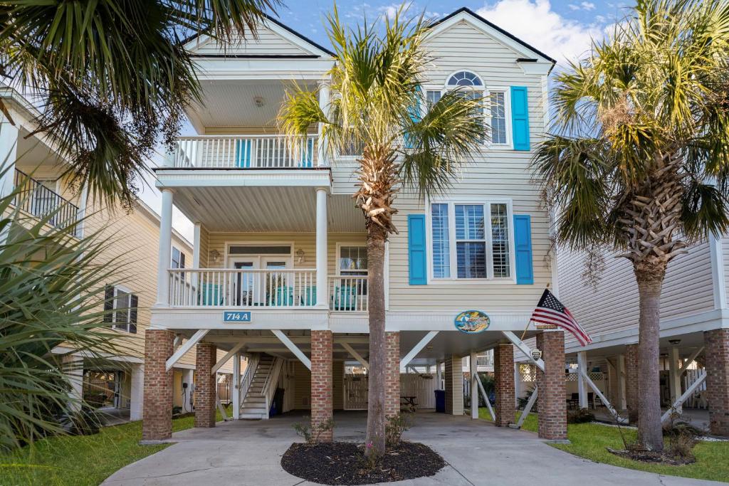 a house with palm trees in front of it at A Sandy Situation in Myrtle Beach