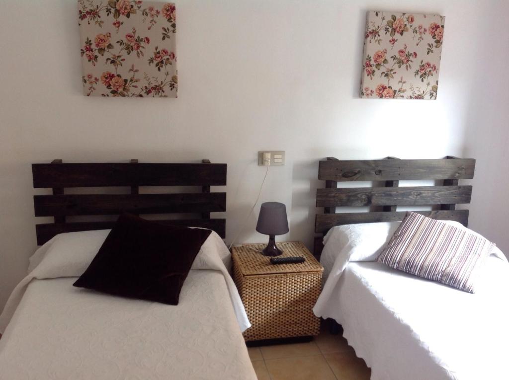 a bedroom with two beds and a lamp on a table at Cal Viudeta in Vilanova de Meyá
