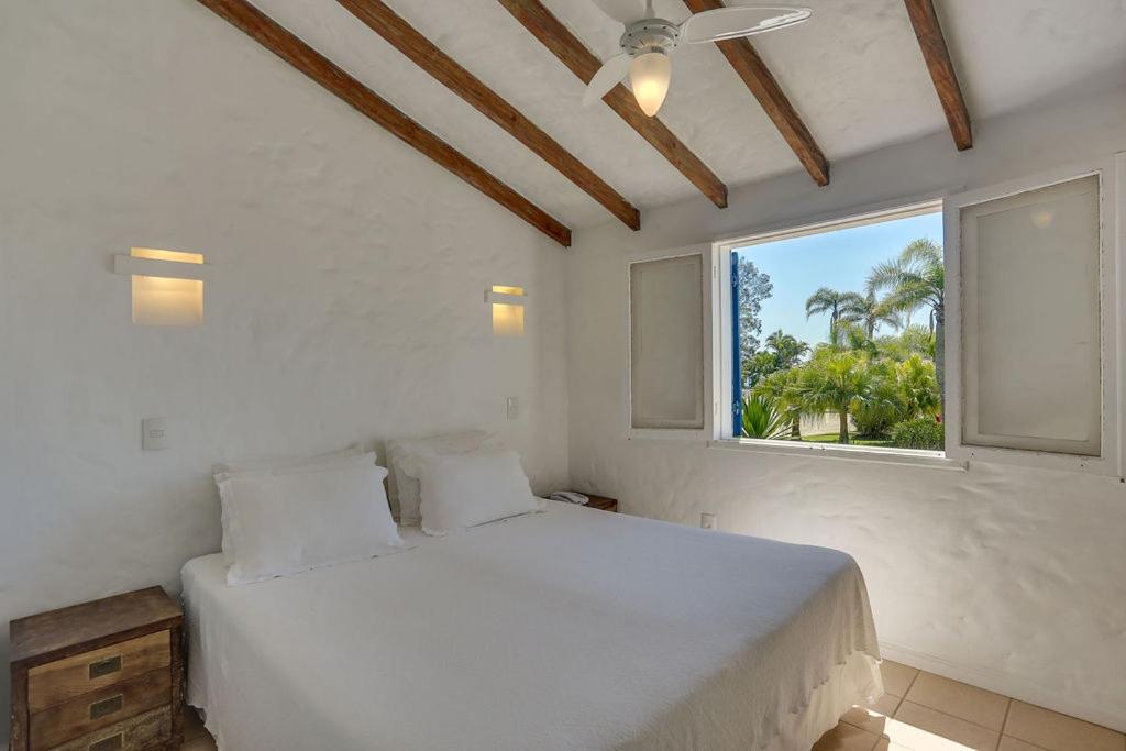 a bedroom with a white bed and a window at Antares Club Hotel Lagoinha in Florianópolis