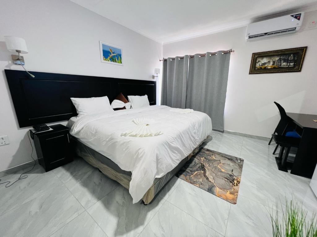 una camera con un grande letto e un tavolo di Maun Nest Hotel a Maun