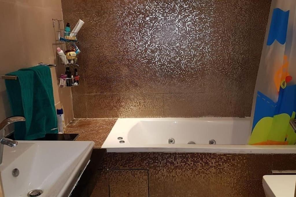 y baño con bañera blanca y ducha. en Appartement-résidence prestigia plage des Nations, en Rabat