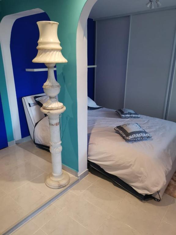 - une chambre avec un lit et une lampe à côté dans l'établissement Mimosas 'Hill, à Mandelieu-la-Napoule