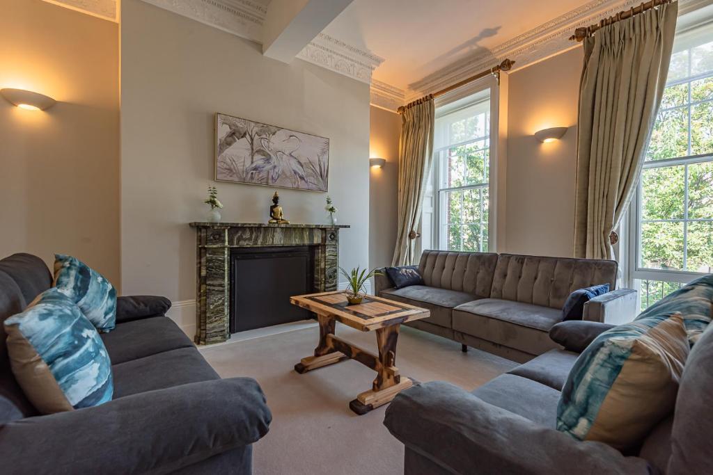 a living room with couches and a fireplace at Luxury flat next to town centre Long-stay discount in Reading