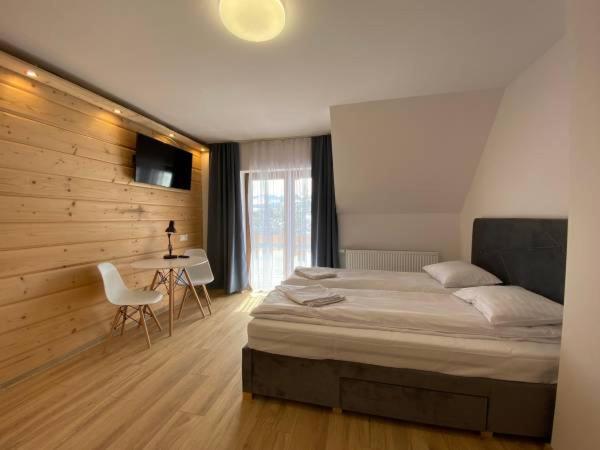 1 dormitorio con 1 cama, 1 mesa y 1 silla en Villa U Skupniów Suche-Zakopane, en Poronin