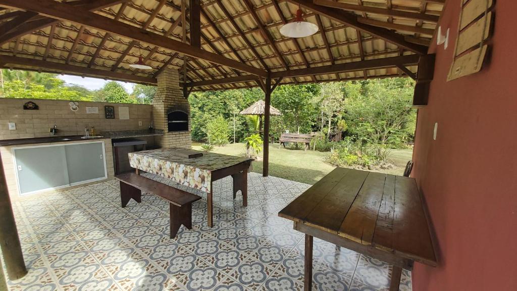een buitenkeuken met een houten tafel en een tafel sidx sidx sidx bij Pousada Sítio Val Paraíso in Sana