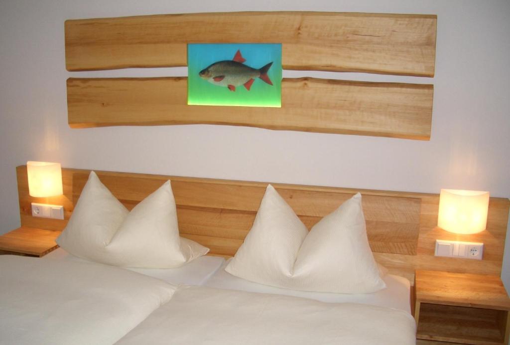 Schlafzimmer mit einem Bett mit einem Fischbild an der Wand in der Unterkunft Karpfenhotel & Herrenhaus im Gasthaus Sindel-Buckel in Feuchtwangen