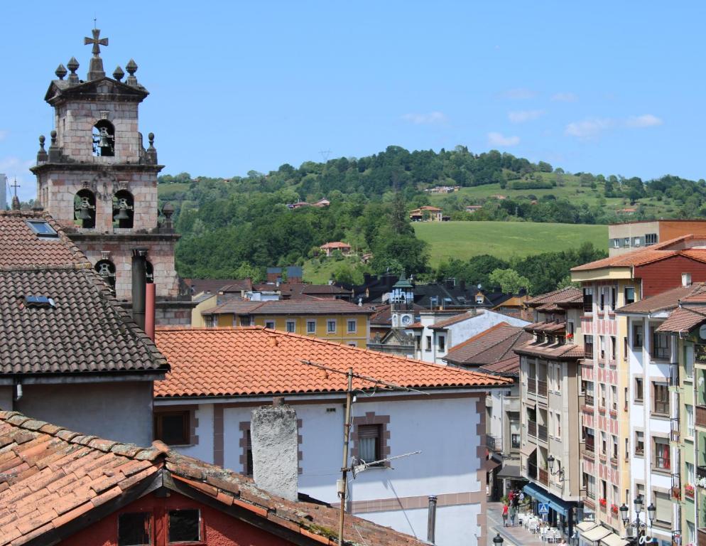 a view of a town with a tower and a church at Apartamentos El Pigazu in Cangas de Onís