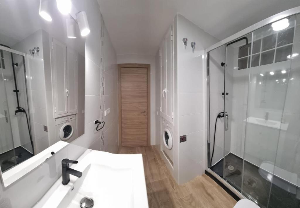 a white bathroom with a sink and a shower at Apartamento Cuevas in Fuengirola