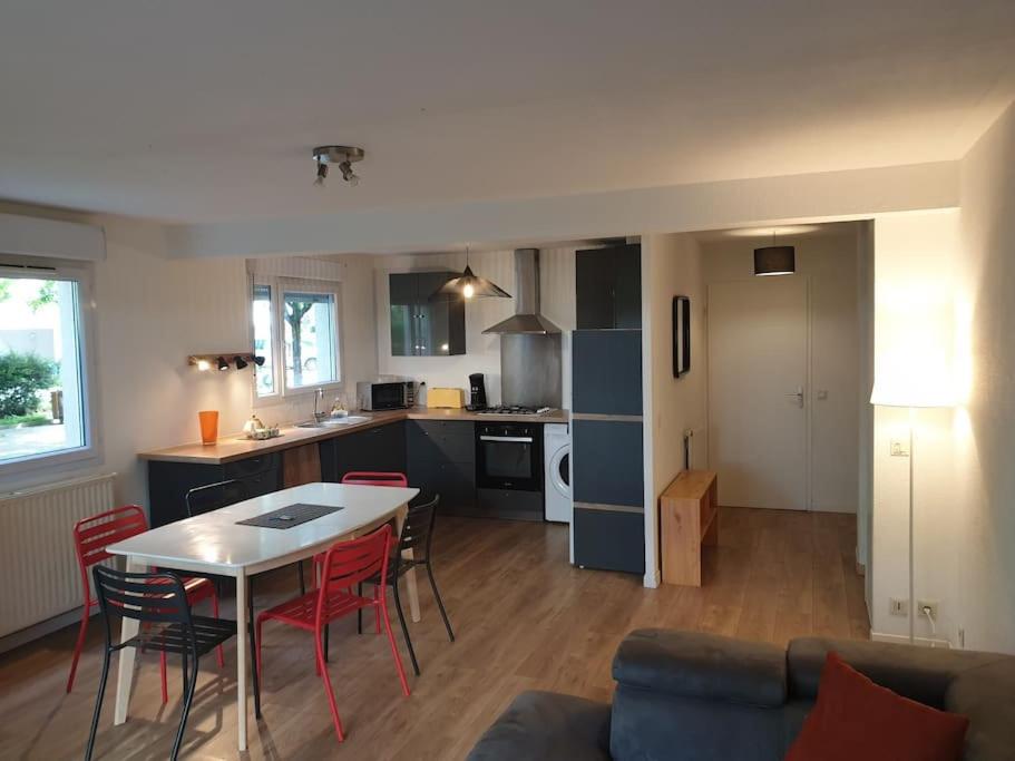 eine Küche und ein Wohnzimmer mit einem Tisch und Stühlen in der Unterkunft 62 m2 Rez de jardin, terrasse , 6 lits et parking in Annecy