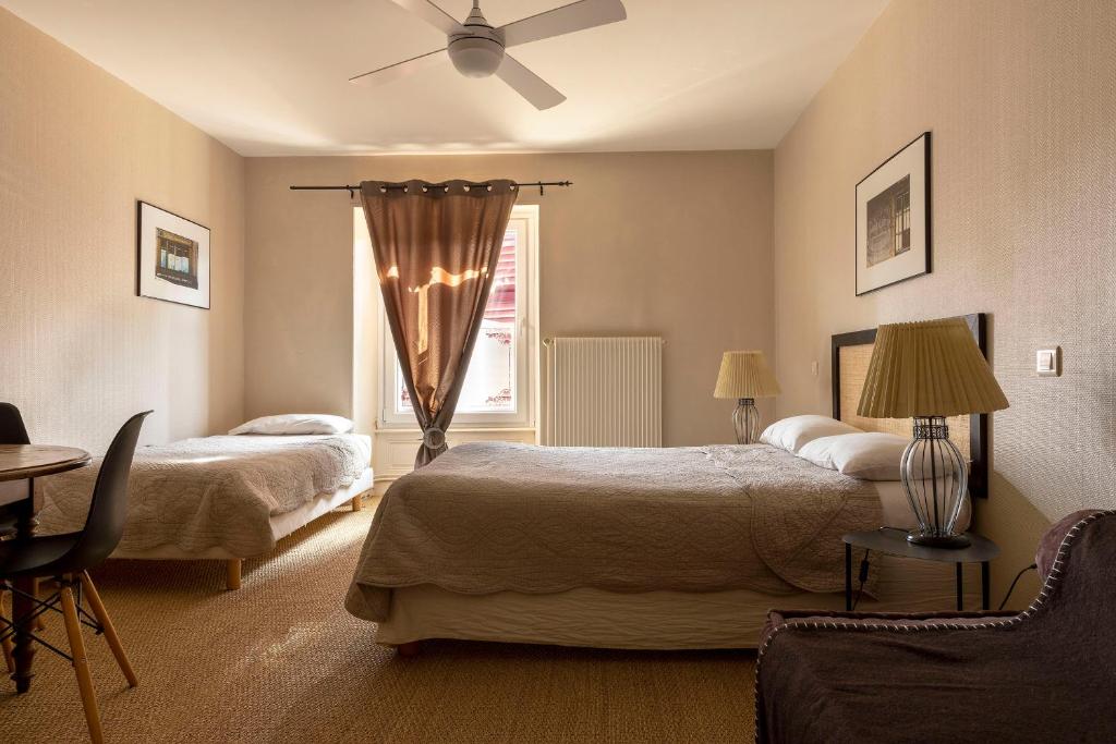 una camera d'albergo con due letti e una finestra di L'Edgar a Port-Lesney