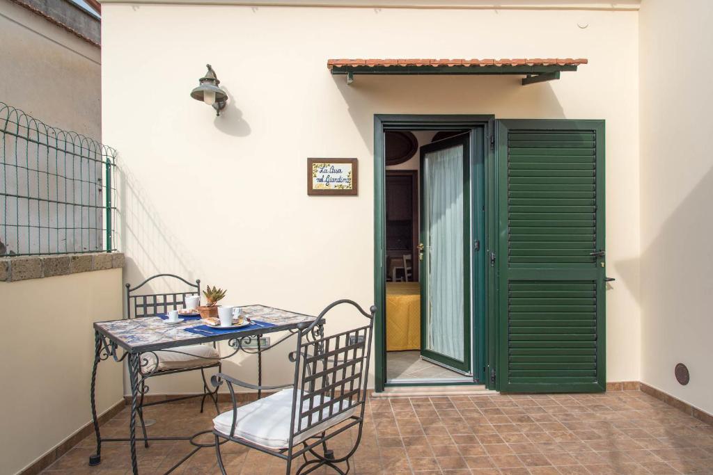 a table and chairs on a patio with a green door at B&B La Casa Nel Giardino in Piano di Sorrento