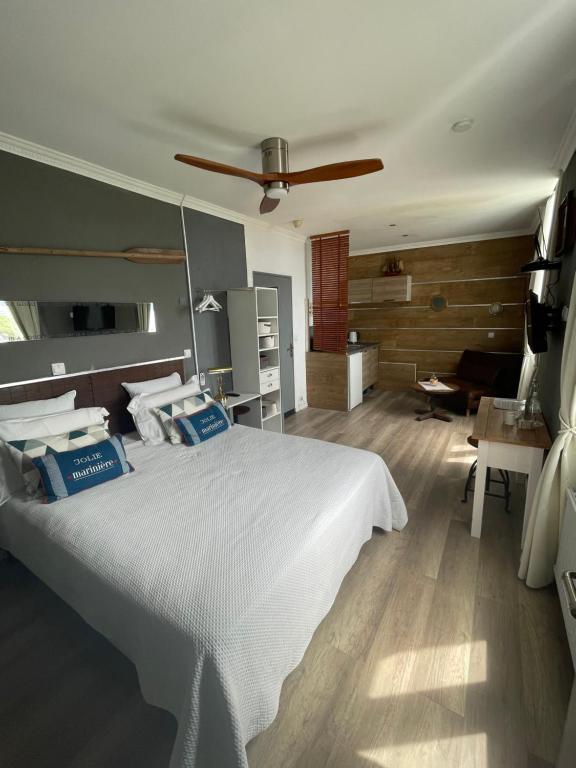 1 dormitorio con 1 cama blanca y ventilador de techo en Villa Les Terrasses à Tamaris vue mer exceptionnelle de chaque chambre, plage en bas du domaine, en La Seyne-sur-Mer