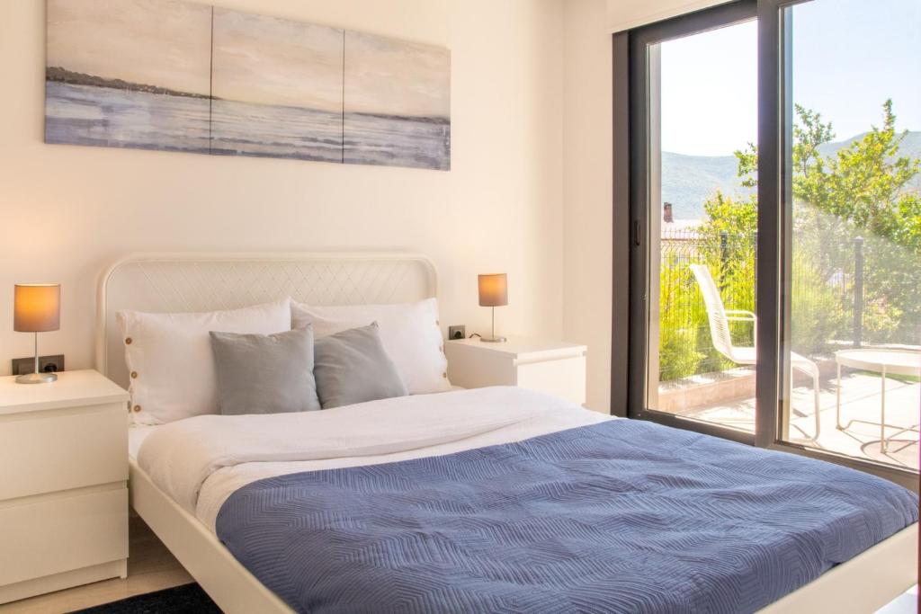 a white bedroom with a bed and a large window at Natur in İzmir